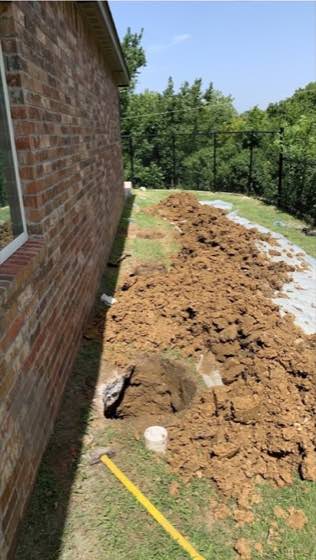 Foundation access trench beside a brick home