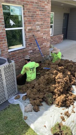 Rock Famous team members working beside a brick home